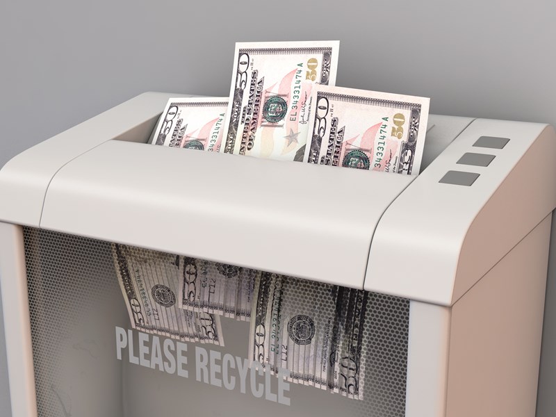 Shredder destroying dollar bills with 'Please Recycle' label, symbolizing wasted money